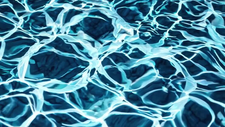 Ripresa video dall'alto di acqua cristallina e azzurra con luce solare che crea increspature e riflessi dinamici