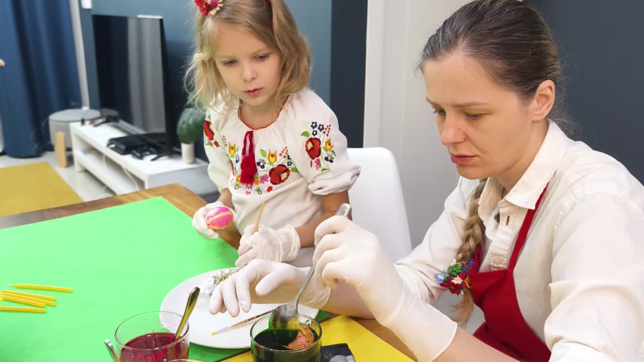мать и дочь рисуют пасхальные яйца