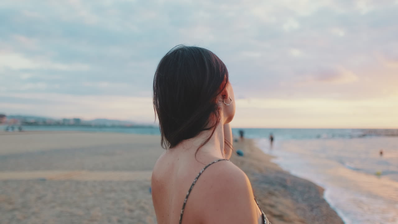 해변에서 해가 지는 것을 즐기는 여자