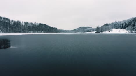 drone flight over partly frozen lake in lithuania