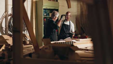 two woodworkers celebrating success in workshop