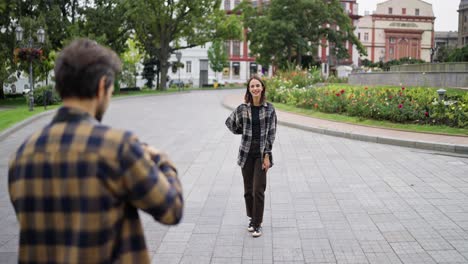 una pareja tomando fotos una de la otra en un parque de la ciudad