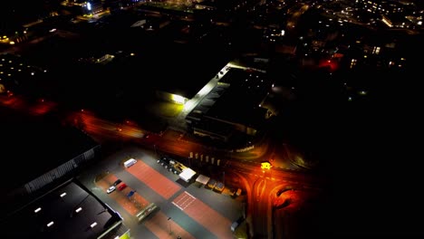 Aerial-Night-View-of-Illuminated-Crossroads-and-Parking-Structure