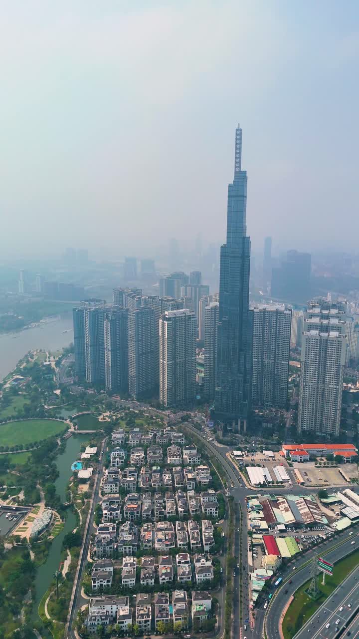 Vertical aerial: Landmark 81 supertall skyscraper during the day with pollution in Ho Chi Minh City, Vietnam