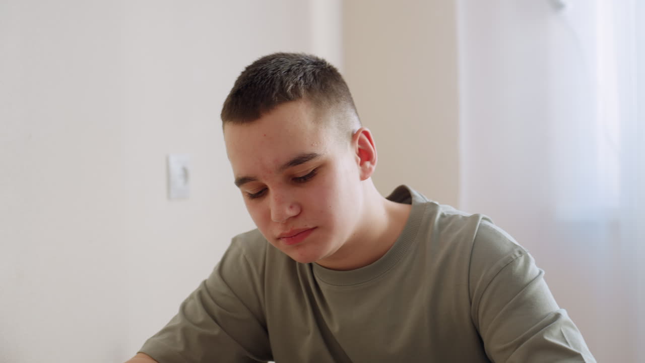 Ragazzo adolescente in camicia casual che mangia pomodori e uova con la forchetta in casa, espressione concentrata, luce naturale sulla parete, ambiente domestico semplice, che mostra un bambino che si gusta un pasto sano fatto in casa