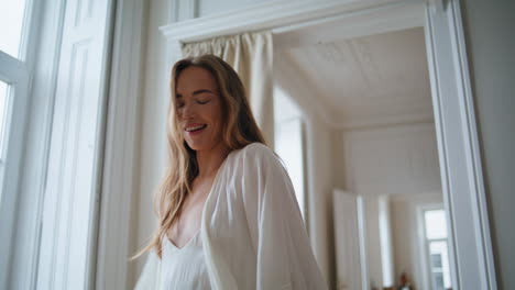 Cheerful-model-walking-morning-apartment-alone.-Positive-girl-looking-camera