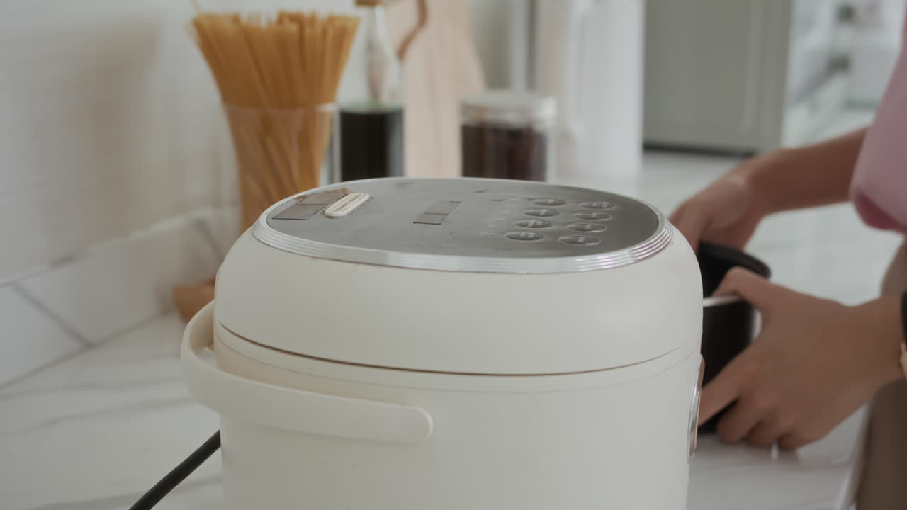 Anonymous Woman Using Multicooker at Home Kitchen