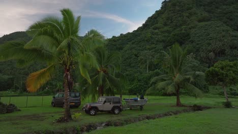 jeep driving boat on trailer surfer sunrise early morning teahupoo tahiti french polynesia aerial drone circle left end of the road olympic venue surf village town buildings island coastline mountains