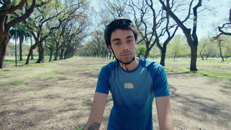 young cyclist posing for camera with bike in the park