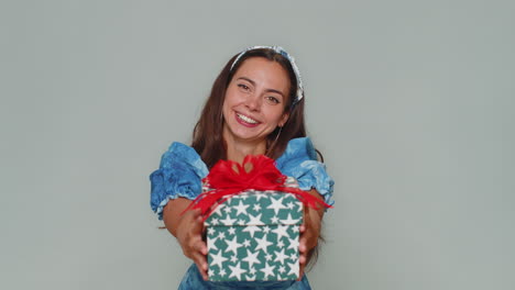 una mujer bonita presenta una caja de regalos de cumpleaños, ofrece un regalo envuelto, bonificación profesional, fiesta de celebración.