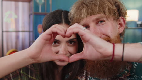 Family married couple makes symbol of love showing heart sign to camera express romantic feelings