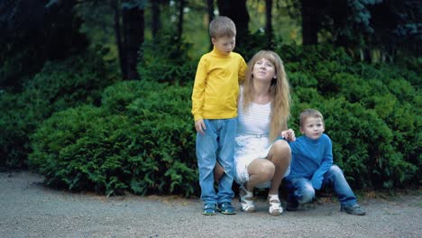 young beautiful mother with two young children hugging