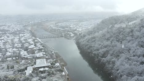 snowfall over kyoto, arashiyama area and togetsu-kyo bridge, aerial view