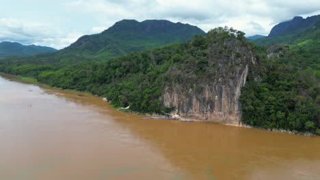 drone flies in on pak ou massif and caves on the mekong river edge in luang prabang laos