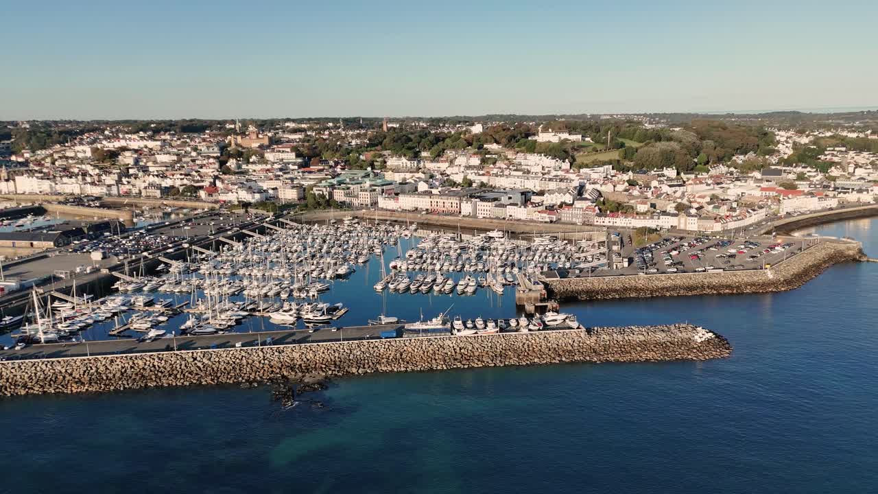 QEII Marina St Peter Port Guernsey, högupplöst drönarfilm som visar hela marinan, Salerie Corner, Glategny Esplanade och utsikt över ön en solig molnfri dag med lugnt klart blått hav