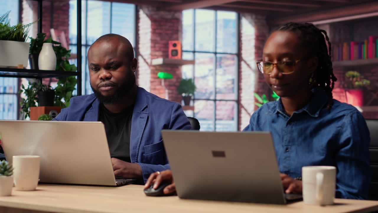 African American man and woman sit at a stylish home office