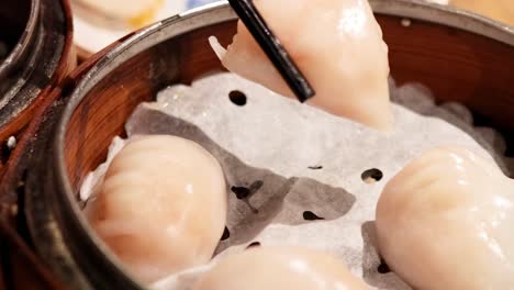 palillos para comer recogiendo albóndigas del vapor de bambú