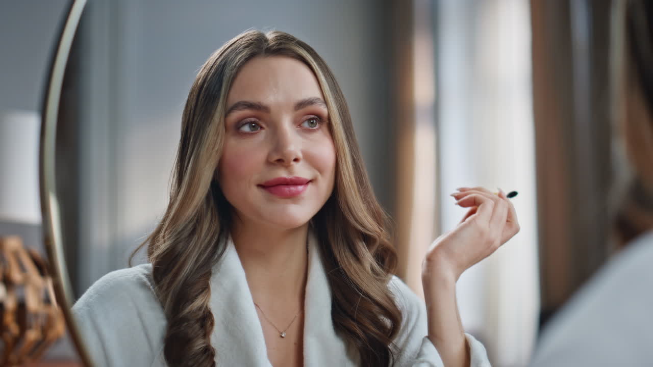 mujer aplicando maquillaje frente a un espejo