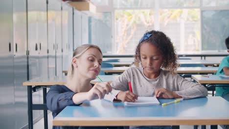 friendly female school teacher helping black schoolgirl