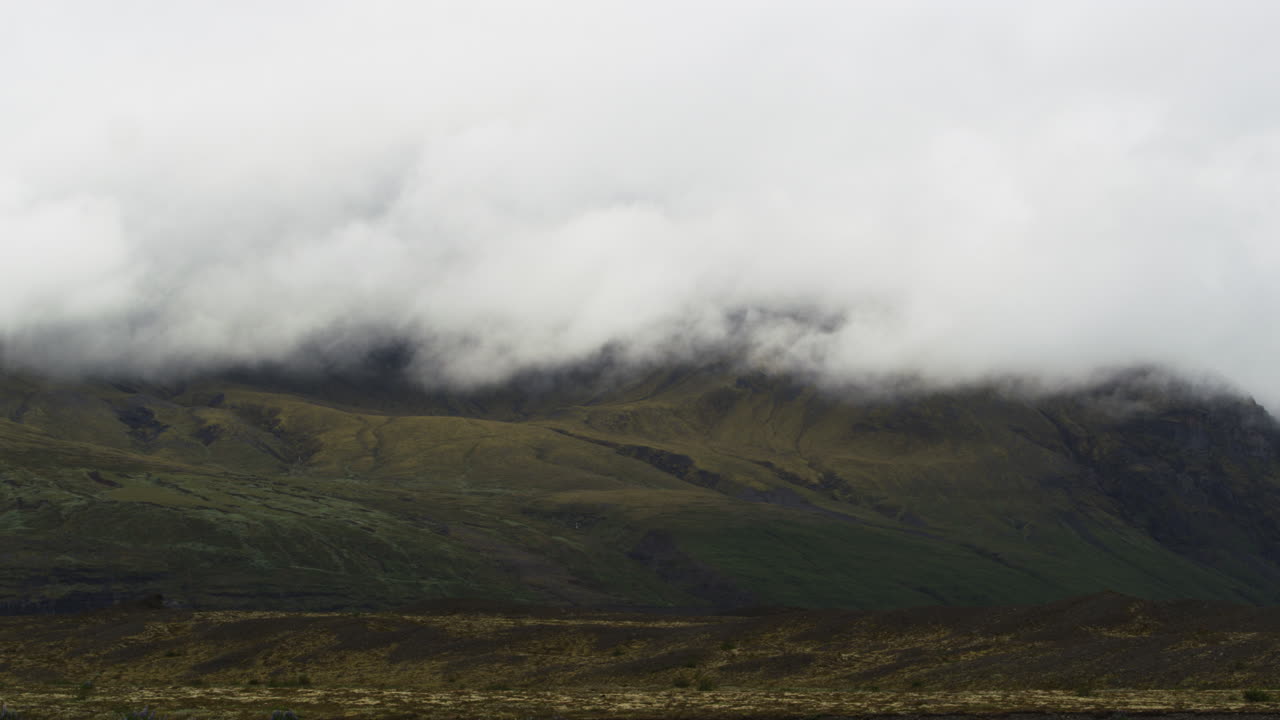 las nubes bajas cubren los picos montañosos de las zonas altas de fjallsárlón en islandia con un gran efecto cinematográfico