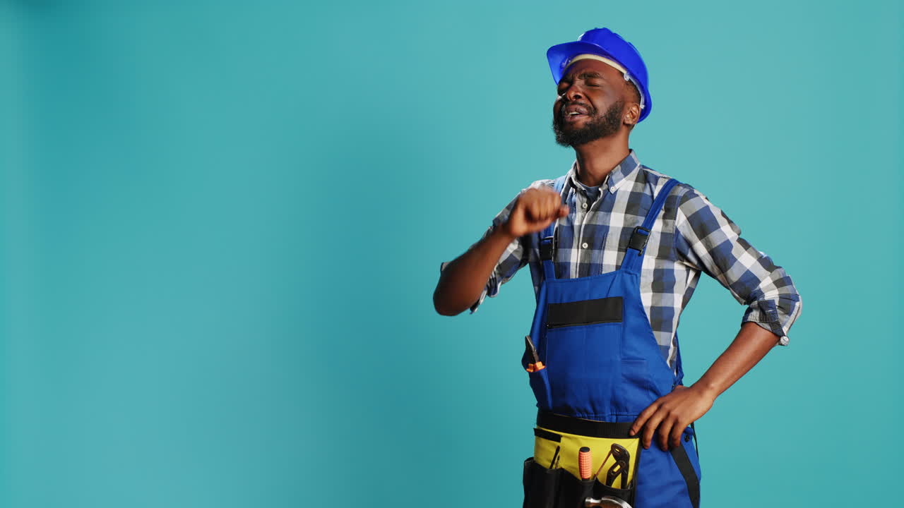 Male builder yawning on camera feeling worn out