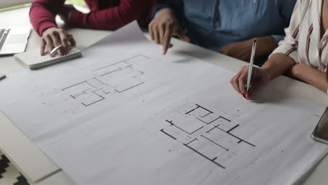 Cropped shot of architects studying blueprints.