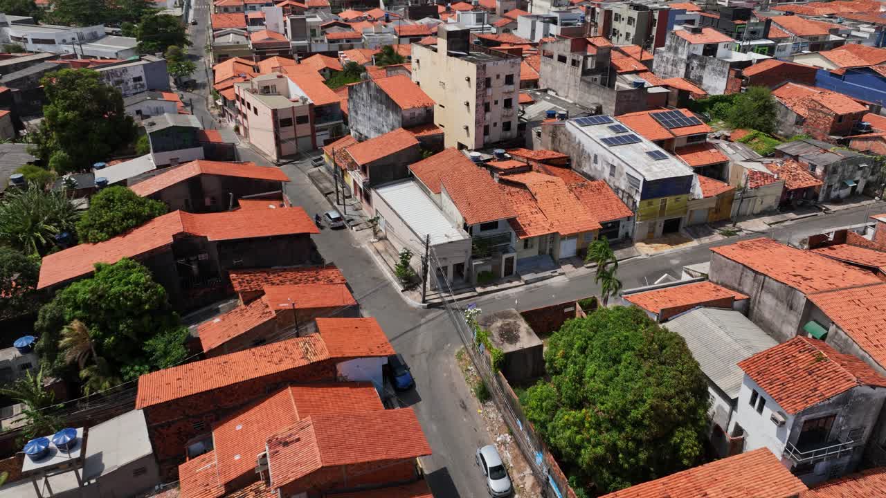 Sao luiz favela with orange rooftops, narrow streets, and green trees, aerial view