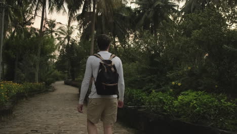 man hiking through tropical garden