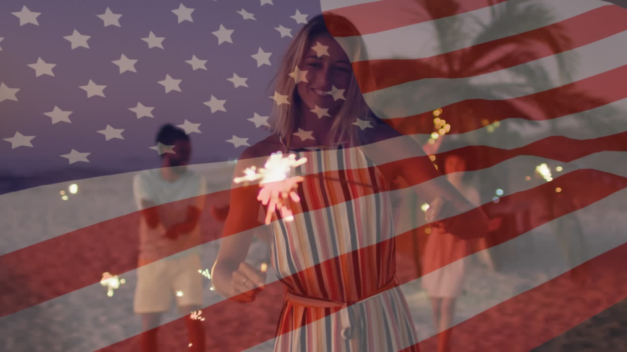 animación de la bandera estadounidense ondeando sobre un grupo de amigos que sostienen chispas en la playa