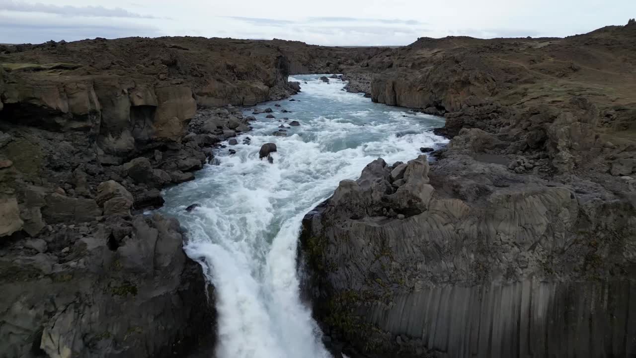 increíble vista aérea de la cascada de aldeyjarfoss en islandia en el verano con el fondo de hermosas columnas de basalto multicolores formadas simétricamente