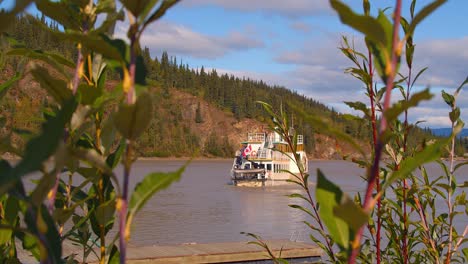 Dampfschiff-Verlassen-Dock-In-Whitehorse,-Kanada-Mit-Blättern-Im-Vordergrund