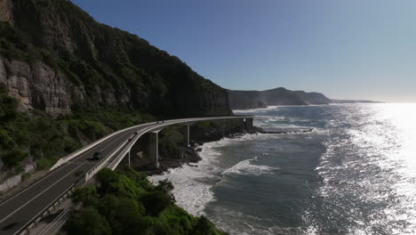 traffic driving over the famous sea cliff bridge in australia on a sunny day