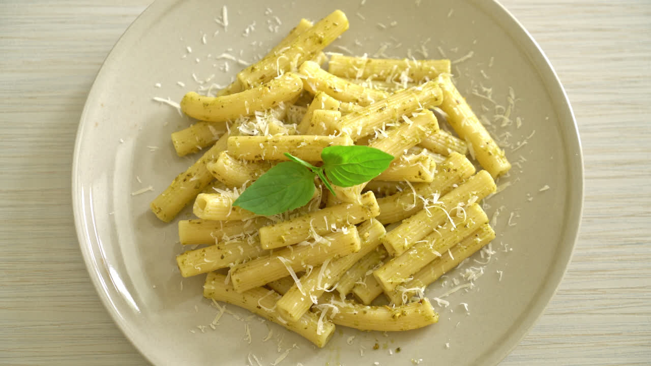 pasta al pesto rigatoni con queso parmesano - comida italiana y comida vegetariana