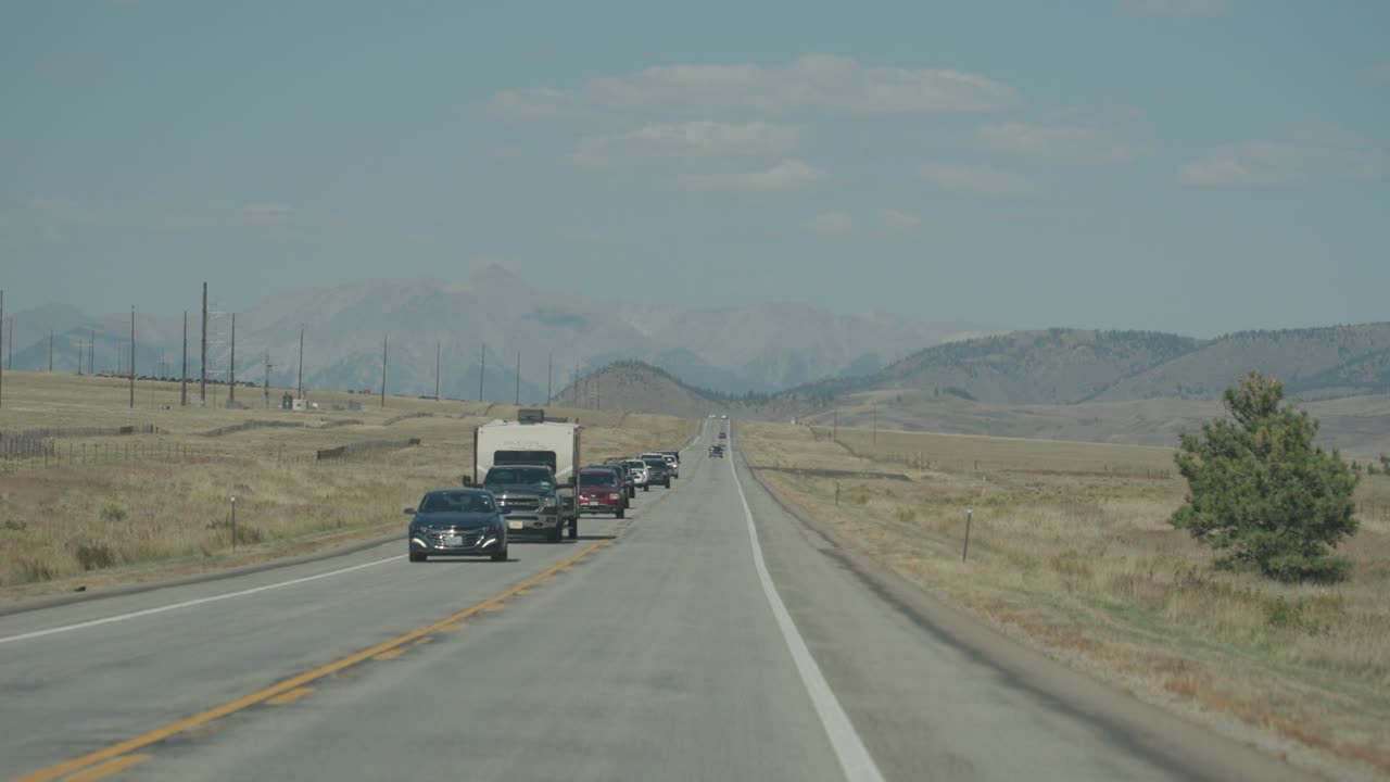 Cars on a road with mountains in the background