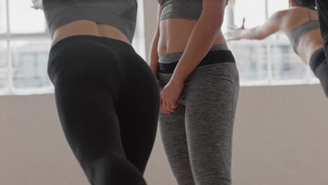 close up yoga woman instructor teaching diverse group practicing warrior pose enjoying healthy lifestyle exercising in fitness studio