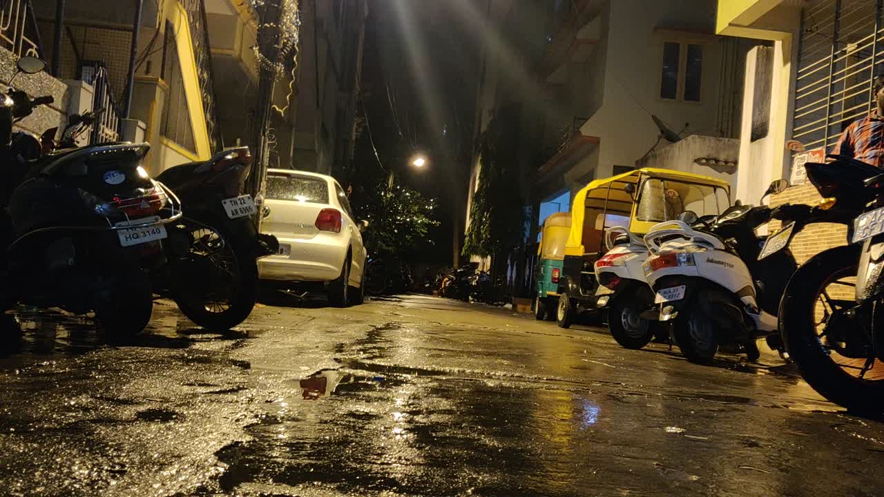 Night Scene on a Wet Urban Street with Parked Vehicles