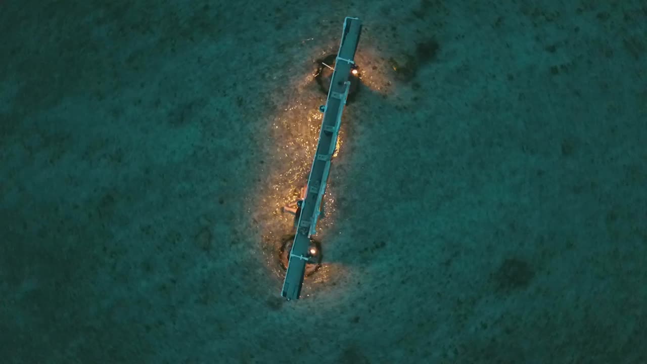 impresionante vuelo aéreo de drones a vista de pájaro toma de un columpio con luces en el agua en una playa de ensueño gili trawangan bali lombok una pequeña isla en la hora azul después del atardecer por philipp marnitz