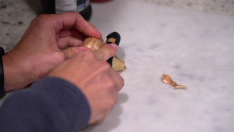 cutting and peeling a fresh piece of ginger root