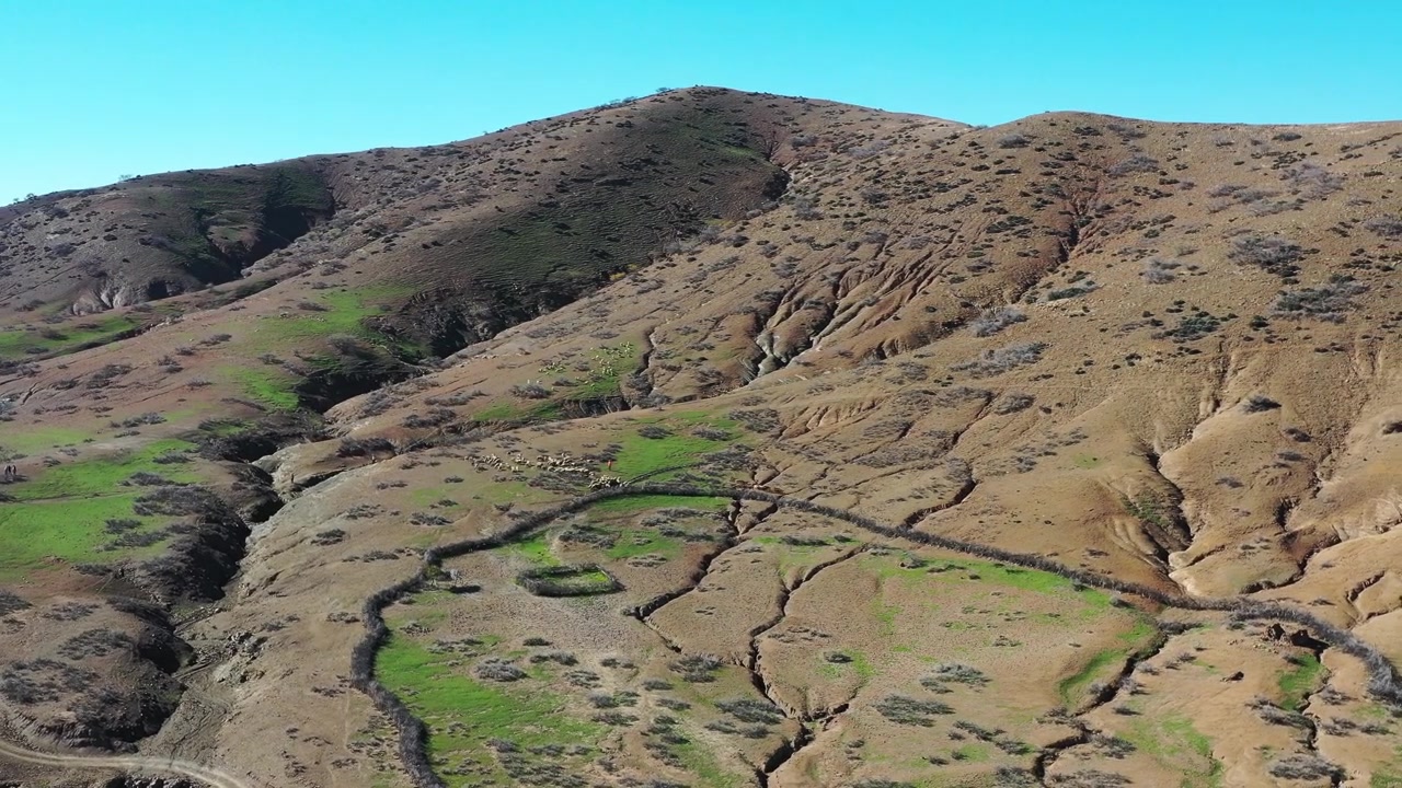 Filmato aereo cinematografico con drone di pendii montuosi erosi che circondano terreni agricoli rurali isolati nel Medio Atlante, Marocco, ideale per progetti ambientali e documentari