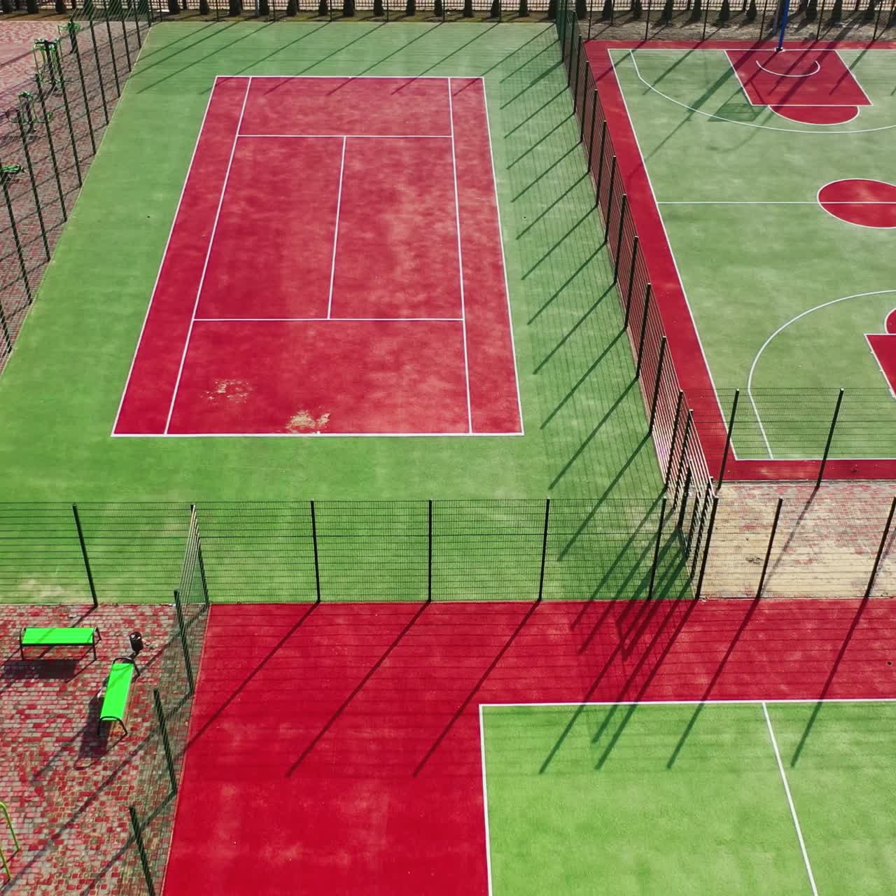Mini stadiums for doing sport outdoors. Modern sport grounds in the city. Red and green sport fields with artificial grass. View from above