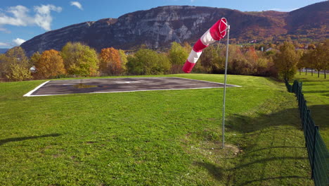 Windsock-waves-in-the-gentle-fall-wind-breeze-next-to-an-helicopter-FATO-4k