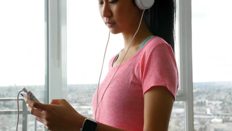 woman in headphones using mobile phone at home 4k