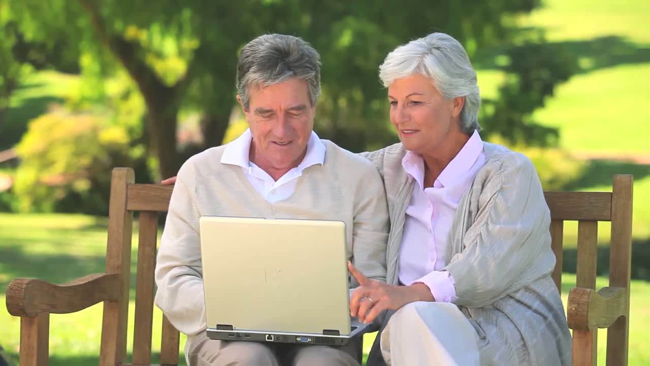 성숙한 커플이 노트북에서 서핑하고 있습니다.