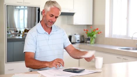 happy man working out finances at the counter