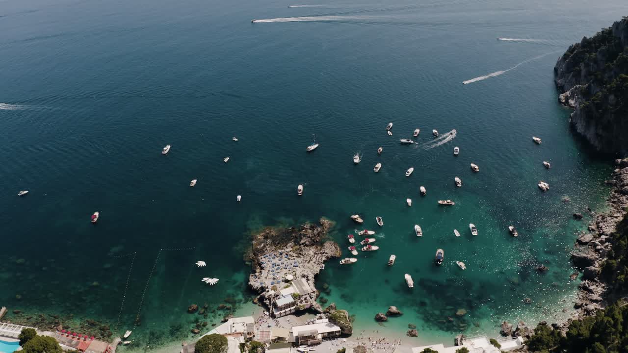 Aerial view of Capri, Italy's shoreline with numerous boats safely moored in the harbor