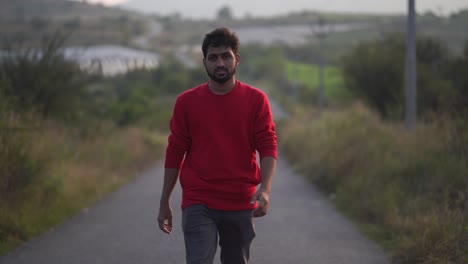 indian man walking away on misty road