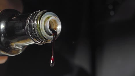 dark liquid pouring from a bottle
