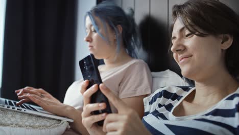 video of lesbian couple in bed with laptop and phone