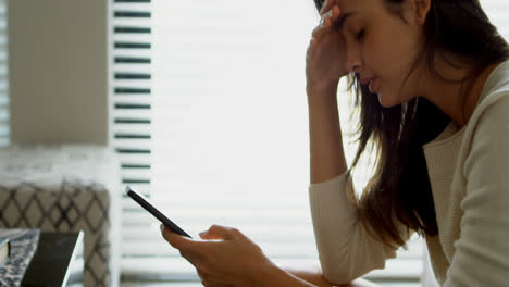 woman using mobile phone on sofa in living room 4k