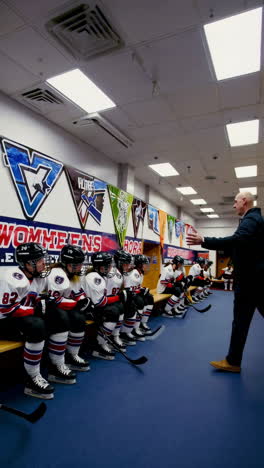 hockey coach giving instructions to team in locker room